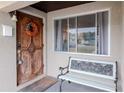 Ornate wood front door with wreath, adjacent bench, and window at 4760 84Th N Ter, Pinellas Park, FL 33781