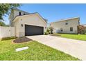 Charming two-story home with gray stucco exterior, dark garage door, and lush landscaping at 11143 Rising Mist Blvd, Riverview, FL 33578