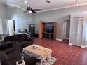 Cozy living room featuring ceiling fan, arched doorways, and tile floors at 12707 Blue Pine Cir, Hudson, FL 34669