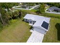 New construction home with a gray roof and a paved driveway at 8126 Chesebro Ave, North Port, FL 34287