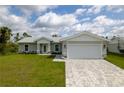 Newly built home with light gray exterior, white garage door, and landscaped lawn at 8126 Chesebro Ave, North Port, FL 34287