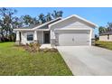 New single-Gathering home featuring a two-car garage, landscaped yard, and gray paint at 2614 58Th E Cir, Palmetto, FL 34221