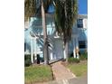 Bright blue building exterior with a walkway and landscaping at 135 Pompano Se Dr # 135, St Petersburg, FL 33705