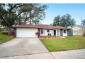 Newly renovated home with a well-manicured lawn and a large driveway at 1413 Sandalwood Dr, Plant City, FL 33563