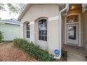 Front entrance of the house with landscaping and ADT security system at 269 Fairmont Dr, Spring Hill, FL 34609