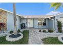 Front entrance with a white door and stone accents, surrounded by landscaping at 5001 Marlin Dr, New Port Richey, FL 34652