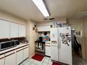 Galley kitchen with white cabinets and stainless steel appliances at 10937 N Lantana Ave, Tampa, FL 33612