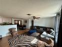 Bright living room featuring a sectional sofa and zebra patterned rug at 122 Gulf Breeze Blvd, Venice, FL 34293