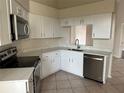 Modern kitchen with white cabinets, quartz countertops, and stainless steel appliances at 4710 Bloom Dr, Plant City, FL 33566