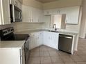 Modern kitchen with white cabinets, quartz countertops, and stainless steel appliances at 4710 Bloom Dr, Plant City, FL 33566