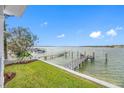 Expansive view of the water from the backyard, featuring a private dock and lush landscaping at 7899 Causeway N Blvd, St Petersburg, FL 33707