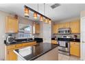 Kitchen with stainless steel appliances, granite countertops, a center island, and light wood cabinets at 19245 Wood Sage Dr, Tampa, FL 33647