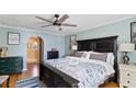 Spacious primary bedroom showcasing a dark wood bed frame, hardwood floors, and light blue walls at 19245 Wood Sage Dr, Tampa, FL 33647