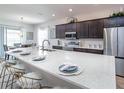 Modern kitchen with large island, white countertops, and stainless steel appliances at 6036 Mangrove Creek Rd, Wimauma, FL 33598