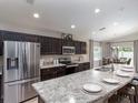 Modern kitchen with stainless steel appliances and large island at 6042 Mangrove Creek Rd, Wimauma, FL 33598