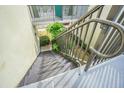 Exterior condo stairs with dark metal railings leading down to the courtyard at 1799 N Highland Ave # 26, Clearwater, FL 33755