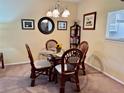 Bright dining area with glass table and four wicker chairs at 936 Virginia St # 208, Dunedin, FL 34698
