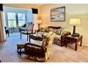 Living room features a comfy sofa, wicker furniture, and access to a sunroom at 936 Virginia St # 208, Dunedin, FL 34698