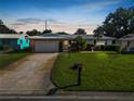 Charming single Gathering home at dusk featuring a well-maintained front lawn and two car garage at 2167 Timber Ln, Clearwater, FL 33763