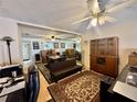 Cozy living room featuring wood laminate floors, ceiling fan and view into the dining area at 11231 Dollar Lake Dr # 1, Port Richey, FL 34668