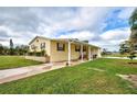 Yellow single-story home with covered porch, landscaped yard, and paved driveway at 3100 Goldfinch Ter, Englewood, FL 34224