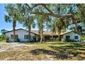 Charming home with mature trees, lush landscaping, and a welcoming entrance at 1061 Owl Dr, Englewood, FL 34223