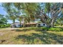 Attractive home featuring a well-maintained lawn and mature, shade-providing trees at 1061 Owl Dr, Englewood, FL 34223