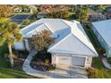 Single-story house with white tile roof and a large yard at 664 Silk Oak Dr, Venice, FL 34293