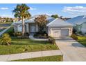 Single-story house with white tile roof and landscaped yard at 664 Silk Oak Dr, Venice, FL 34293