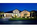 Luxury home exterior at night, showcasing landscaping and lighting at 284 Bocelli Dr., Nokomis, FL 34275