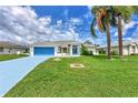 Front view of a house with blue garage door and driveway, surrounded by lush lawn at 5888 Garfield Rd, Venice, FL 34293