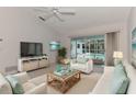 Bright living room with white sofas, coffee table, and view of the pool at 5888 Garfield Rd, Venice, FL 34293