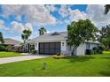 Single-story home with attached garage, landscaping, and a spacious lawn at 9 Bunker Ln, Rotonda West, FL 33947