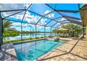 Screened-in pool and spa with lake view and patio furniture at 13587 Vancanza Dr, Venice, FL 34293