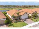 Single-story home with a terracotta roof, palm trees, and a brick driveway at 10133 Colubrina Dr, Venice, FL 34293