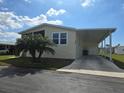 Charming home with a screened-in porch, carport, and a well-maintained front lawn on a sunny day at 428 Boxwood Dr, Venice, FL 34285