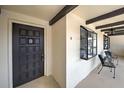 Welcoming condo entrance with decorative door, exterior display case, and cozy seating area at 766 Avenida Estancia # 196, Venice, FL 34292