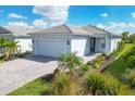 Charming single-story home featuring a brick driveway, a two-car garage, and well-maintained landscaping at 25544 Royal Tern Ln, Englewood, FL 34223