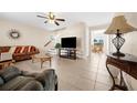 Living room with tiled floors, sectional sofa, and a large TV at 617 Rose Apple Cir, Port Charlotte, FL 33954