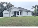 White house with a two-car garage and partial view of the backyard at 15467 Maynard Ave, Port Charlotte, FL 33953