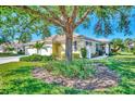Exterior of a house with a large tree and well-maintained yard at 1599 Monarch Dr # 1599, Venice, FL 34293