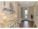 Light and bright entry hall with decorative console table and hardwood floors at 13097 Rinella St, Venice, FL 34293