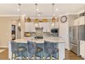 Modern kitchen with white cabinets, quartz countertops, and island with seating at 13097 Rinella St, Venice, FL 34293