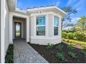 Inviting front entry with a paved walkway and well-manicured landscaping at 26056 Seastone Dr, Englewood, FL 34223