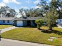 Single-story house with a green exterior, driveway, and yard at 1323 Karen Dr, Venice, FL 34285