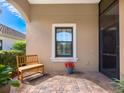 Covered front porch with a wooden bench, potted plants, and a view of the street at 21621 Winter Park Ct, Venice, FL 34293