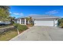 White house with metal roof, landscaping, and attached garage at 23442 Moreland Ave, Port Charlotte, FL 33954