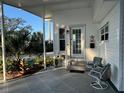 Charming covered front porch with a water feature, seating, and view of the landscaping at 789 N Green Cir, Venice, FL 34285