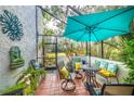 Relaxing screened patio with seating area, umbrella, and lush landscaping at 864 Bird Bay Way # 195, Venice, FL 34285