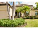 Landscaped front yard with palm trees and well-maintained lawn at 20314 Passagio Dr, Venice, FL 34293